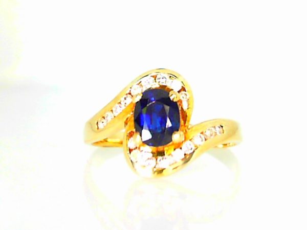 Lady's Yellow 14 Karat Free Form Fashion Ring Size 7 one Oval Sapphire
18=0.10tw Round Diamonds