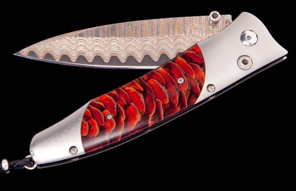 The Gentac ‘Red Sun' features a light and resilient frame in aerospace grade titanium, inlaid with stabilized Blue Spruce Pine Cone. The blade is 'Copper Wave' damascus with a core of VG5 steel; the one-hand button lock and the thumb stud are set with spinel. An exceptional design that offers rigorous performance in a sleek, comfortable knife, the Gentac is also the perfect canvas to showcase William Henry’s range of exotic materials and techniques. The 'Red Sun’ features some of the hi-tech materials and hand-forged metals that are the hallmark of William Henry's collections; a modern design for a timeless heirloom to be proudly worn and used for a lifetime before being handed-down to another generation.
FEATURES & SPECS
One-hand button lock system
Shipped in an elegant wood presentation box
Dimensions: 
Blade 3.25" (82.5mm)
Handle 3.80" (96.5mm)
Overall open 7.00" (177.8mm) - Image 2