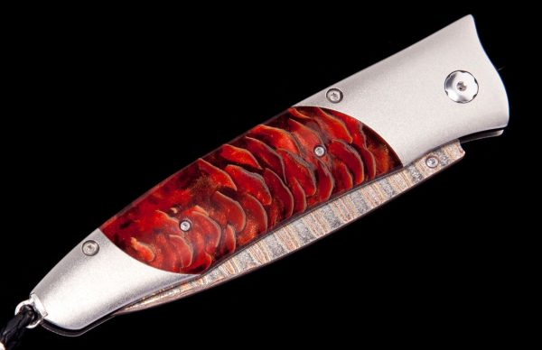 The Gentac ‘Red Sun' features a light and resilient frame in aerospace grade titanium, inlaid with stabilized Blue Spruce Pine Cone. The blade is 'Copper Wave' damascus with a core of VG5 steel; the one-hand button lock and the thumb stud are set with spinel. An exceptional design that offers rigorous performance in a sleek, comfortable knife, the Gentac is also the perfect canvas to showcase William Henry’s range of exotic materials and techniques. The 'Red Sun’ features some of the hi-tech materials and hand-forged metals that are the hallmark of William Henry's collections; a modern design for a timeless heirloom to be proudly worn and used for a lifetime before being handed-down to another generation.
FEATURES & SPECS
One-hand button lock system
Shipped in an elegant wood presentation box
Dimensions: 
Blade 3.25" (82.5mm)
Handle 3.80" (96.5mm)
Overall open 7.00" (177.8mm) - Image 3