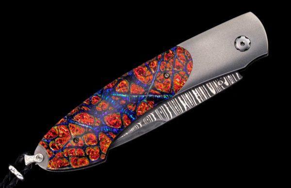 The Spearpoint ‘Red Flash' features a frame in aerospace-grade titanium, inlaid with 'Red Burl' Dichrolam®. The blade is 'Wave' damascus with VG-10 core; the one-hand button lock and the thumb stud are set with Kashmir blue gemstones.

Limited Edition 39/250